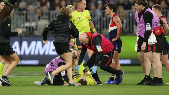 Field umpire Alex Whetton lies on the field after being on the receiving end of a heavy collision. Picture: Getty Images