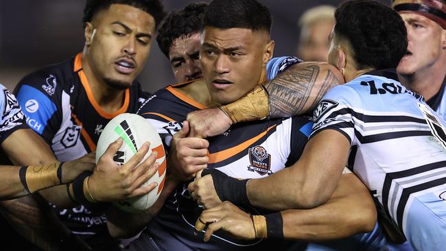 SYDNEY, AUSTRALIA - JULY 12:  Stefano Utoikamanu of the Wests Tigers is tackled during the round 19 NRL match between Cronulla Sharks and Wests Tigers at PointsBet Stadium on July 12, 2024, in Sydney, Australia. (Photo by Brendon Thorne/Getty Images)