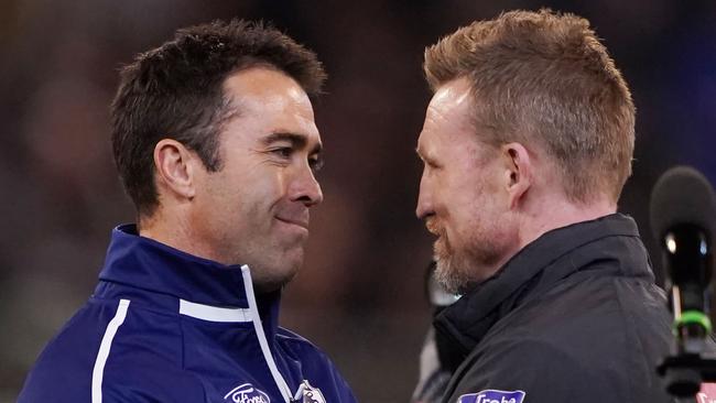 Cats head coach Chris Scott (left) shakes hands with Magpies head coach Nathan Buckley during the First Qualifying Final.