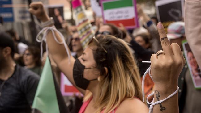 A woman gestures with her middle finger in the direction of the Iranian Consulate in Istanbul, Turkey.