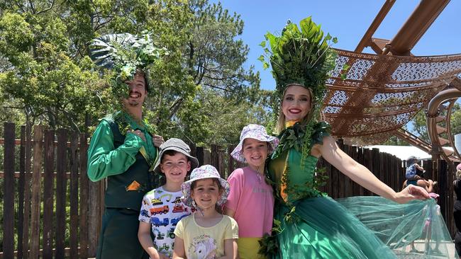 Oliver Jamieson (6), Allaria Plack (5) and Ava Jamieson (9) with Dreamworld performers at the opening of the theme park's $55m Rivertown precinct. Picture: Rosie Gale