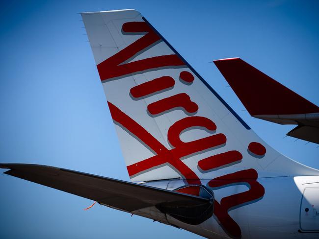 Virgin Australia aircraft are seen parked on the tarmac at Brisbane International airport on April 21, 2020. - Cash-strapped Virgin Australia collapsed on April 21, making it the largest carrier yet to buckle under the strain of the coronavirus pandemic, which has ravaged the global airline industry. (Photo by Patrick HAMILTON / AFP)