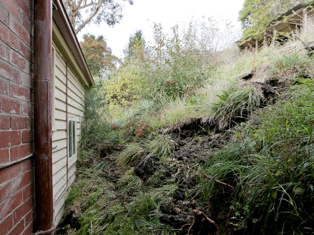 The aftermath of a landslide in the backyard of the Paice family’s Sandy Bay home, which left piles of dirt, rocks, mud and plants piled against the back of the house. Picture: PATRICK GEE