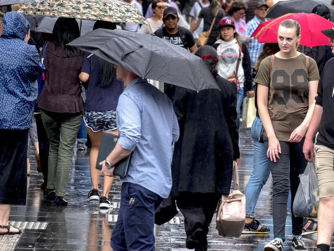 People walk in the rain in the CBD, in Melbourne, where 100mm of rain has been forecast. Picture: Image/Luis Enrique Ascui