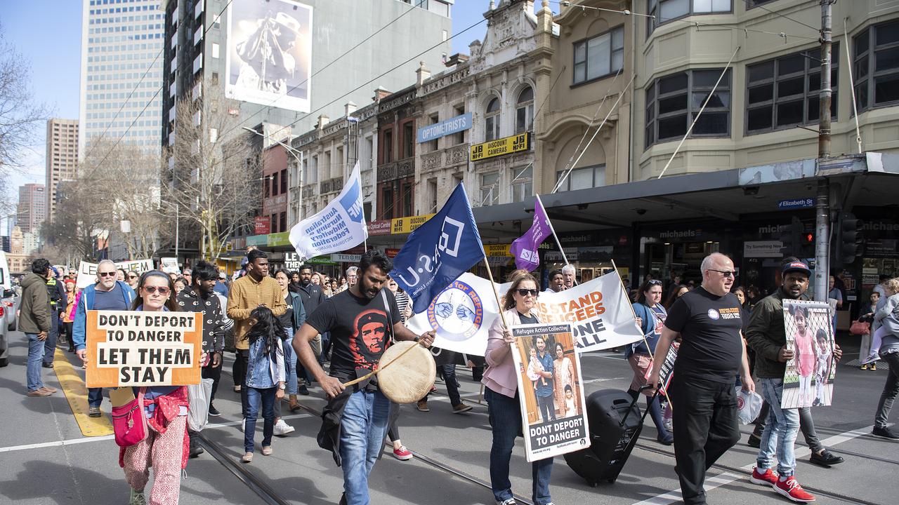 Protesters hold placards during the Let Them Stay rally at the State Library of Victoria. Picture: AAP Image/Ellen Smith.