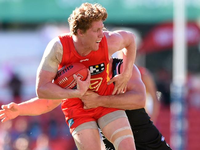 Matt Rowell rides a Port Adelaide tackle.