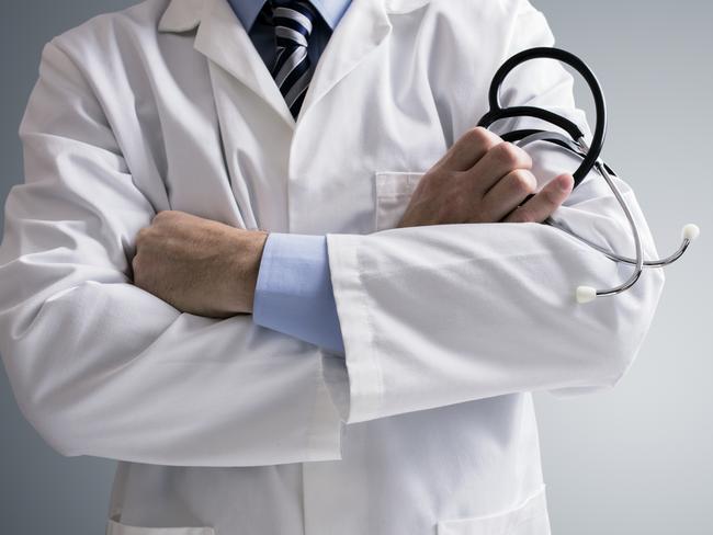 Doctor holding a stethoscope with arms crossed and copy space