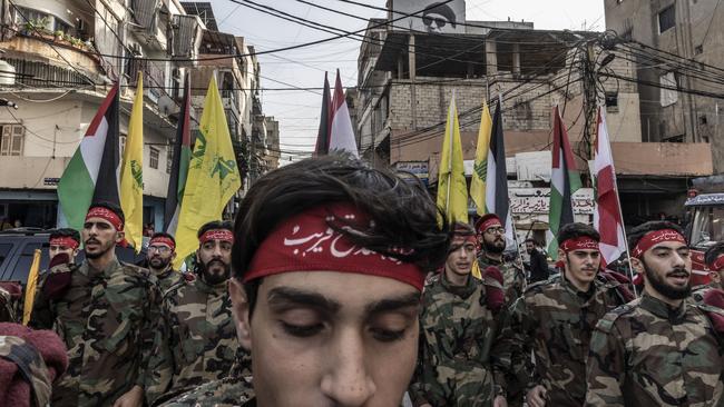 Hezbollah supporters in military clothes in formation. Picture: Getty Images