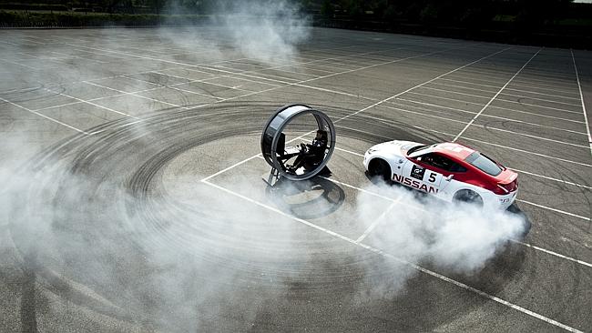 That’s off putting. Nissan 370Z doing doughnuts around a Sony PlayStation gaming pod