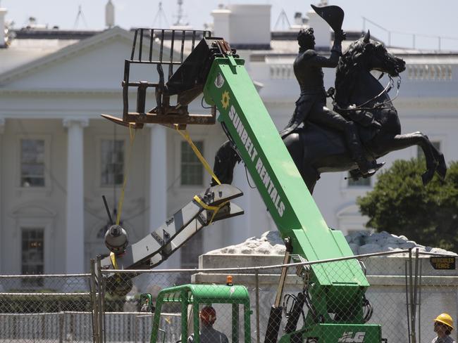 Workers remove part of the cannon at the base of the equestrian statue of President Andrew Jackson in front of the White House. Picture: AP