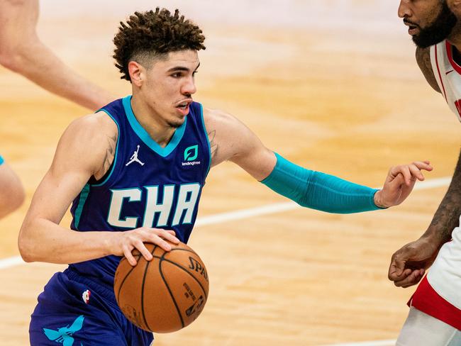 CHARLOTTE, NORTH CAROLINA - FEBRUARY 08: LaMelo Ball #2 of the Charlotte Hornets drives to the basket while guarded by DeMarcus Cousins #15 of the Houston Rockets during the third quarter at Spectrum Center on February 08, 2021 in Charlotte, North Carolina. NOTE TO USER: User expressly acknowledges and agrees that, by downloading and or using this photograph, User is consenting to the terms and conditions of the Getty Images License Agreement.   Jacob Kupferman/Getty Images/AFP == FOR NEWSPAPERS, INTERNET, TELCOS & TELEVISION USE ONLY ==