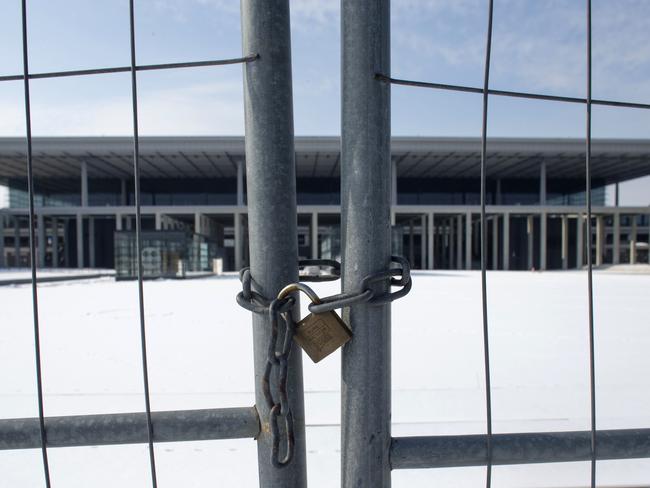 FILE - In this March 14, 2013  file photo, a fence shields the main terminal of the new Berlin Brandenburg International Airport  named Willy-Brandt-Flughafen in Schoenefeld near Berlin.  A member of Berlinâ€™s state government, Engelbert Luetke Daldrup, on Monday took over the helm from Karsten Muehlenfeld who left the job prematurely after an endless series of cost overruns and technical and personnel problems that have led to ongoing delays in the opening of the new airport, which was initially touted as a national prestige project. (AP Photo/Markus Schreiber,file)