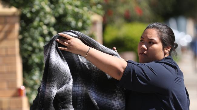 A family member covers a blanket on Kalati as she leaves court. Picture: John Grainger