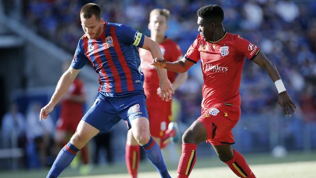 Adelaide United’s Al Hassan Tours looks set to steal the ball from Newcastle Jets captain Nigel Boogaard in the round 3 2-1 win away. (AAP Image/Darren Pateman)