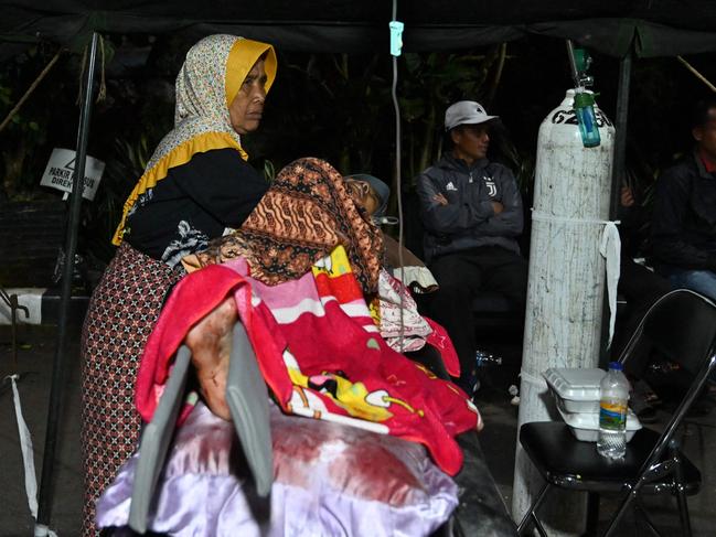 Wounded people rest under a tent outside a hospital in Cianjur. Picture: AFP.