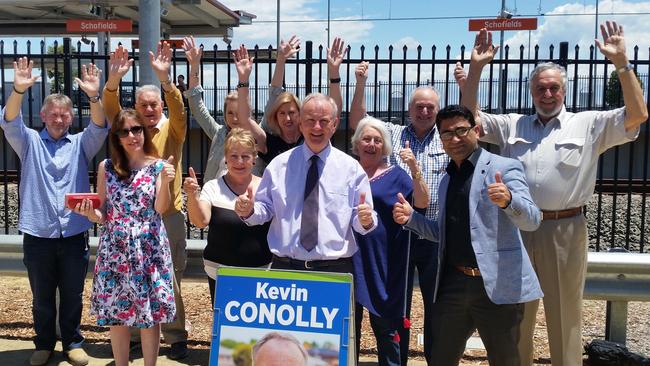 Kevin Conolly (centre) with commuters at Schofields train station celebrating the news.