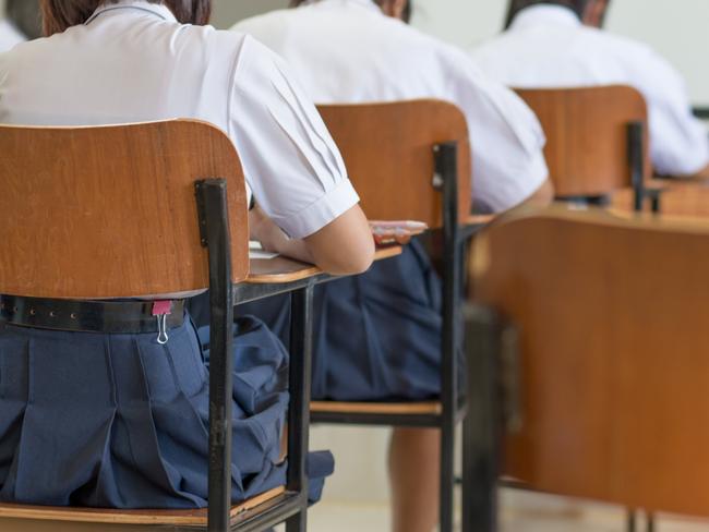 Asian students reading and writing a test in exercise, exam in classroom : education concept