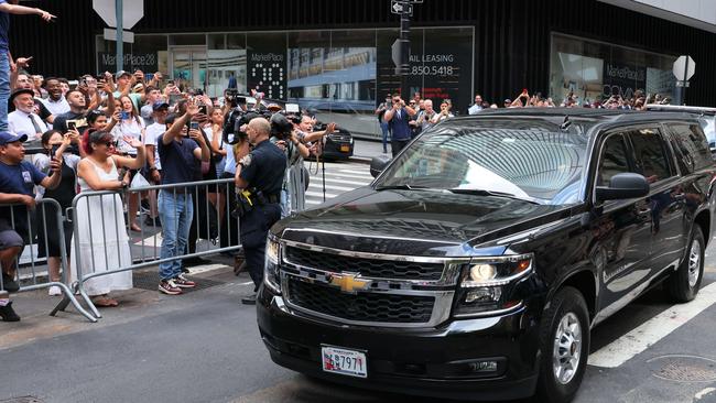 People wave as Former President Donald Trump drives by after sitting for a deposition at the office of the NYS Attorney General on August 10.