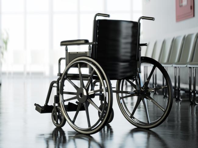 Standard manual wheelchair standing in empty hospital corridor