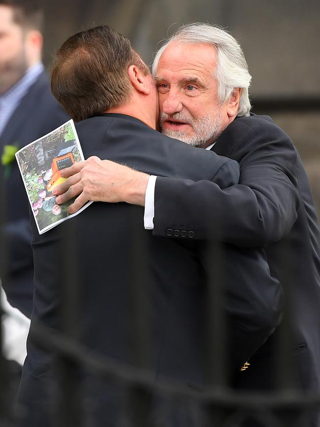 Others, in traditional black, embraced. Picture: Quinn Rooney/Getty