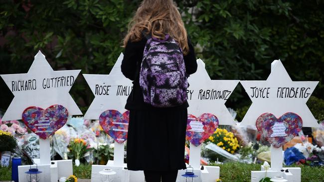 A woman stands at a memorial outside the Tree of Life synagogue after a shooting there left 11 people dead in the Squirrel Hill neighborhood of Pittsburgh.