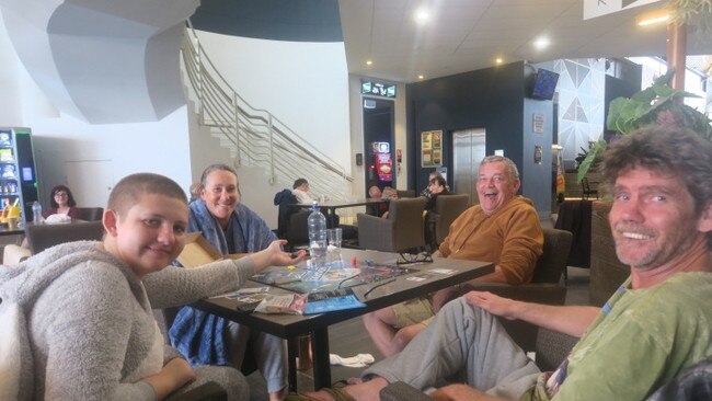 Zoe Jahnsen, left, and her father Gary, top right, with neighbours at Port Panthers evacuation centre. Picture: Daniel Mills