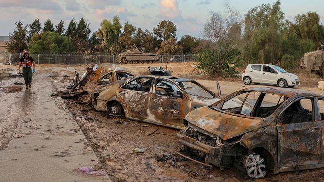 A rescuer walks past destroyed cars at scene of an attack in the Israeli kibbutz of Kfar Aza. Picture: AFP