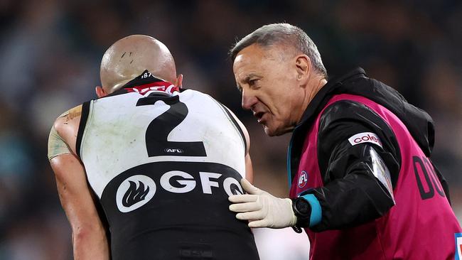 ADELAIDE, AUSTRALIA - JULY 22: Sam Powell-Pepper of the Power in the hands of the club doctor during the 2023 AFL Round 19 match between the Port Adelaide Power and the Collingwood Magpies at Adelaide Oval on July 22, 2023 in Adelaide, Australia. (Photo by Sarah Reed/AFL Photos via Getty Images)