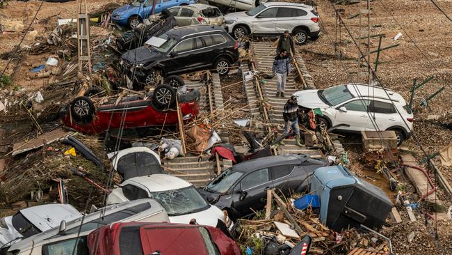 Cars and a campervan are strewn over railway tracks after being swept up in flash flooding in Valencia. Picture: Getty Images.