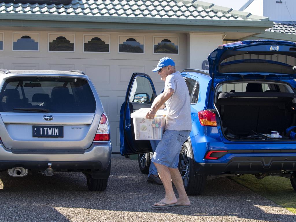 Paul Dawson moves items into his daughter’s house at Biggera Waters on the Gold Coast. Picture: Glenn Hunt.