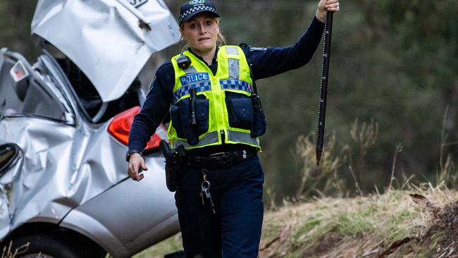 A Major Crash Investigation Branch officer takes measurements at the scene of the fatal crash on Montacute Road, Athelstone. Picture: Tom Huntley