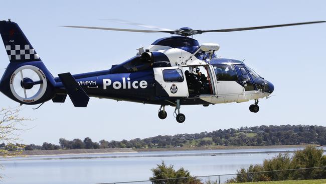 A Victoria Police helicopter takes off at Sugarloaf Reservoir during the search for John Forster. Picture: David Caird