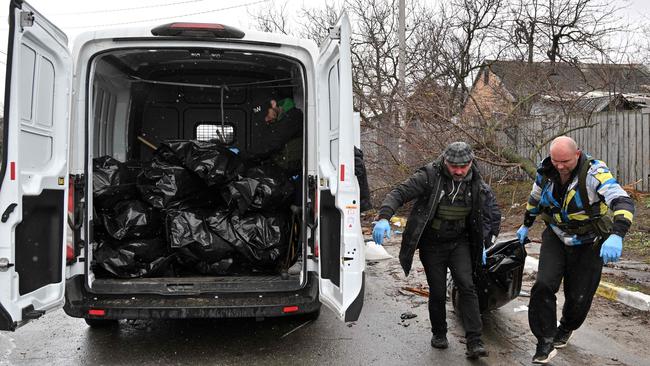 Communal workers carry a body of a civilian man killed by Russian troops shelling in town of Bucha, not far from the Ukrainian capital of Kyiv on April 3. Picture: Sergei SUPINSKY / AFP