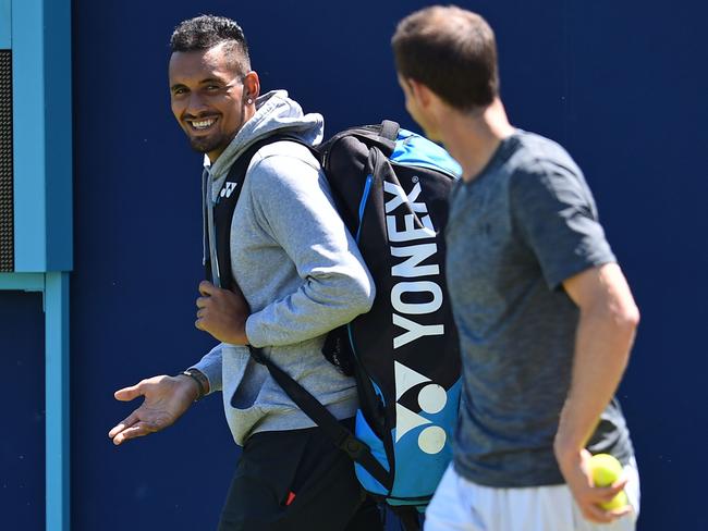 Australia's Nick Kyrgios (L) has a word with Britain's Andy Murray as he practices, ahead of their first round match at the ATP Queen's Club Championships tennis tournament in west London on June 18, 2018. Finally recovered after hip surgery in January, Murray will play his first competitive match for 11 months in the Queen's Club first round next week. / AFP PHOTO / Glyn KIRK