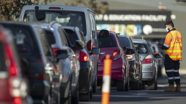 Staff direct traffic in massive queues waiting to get into a pop-up COVID-19 test site in Fawkner in Melbourne.