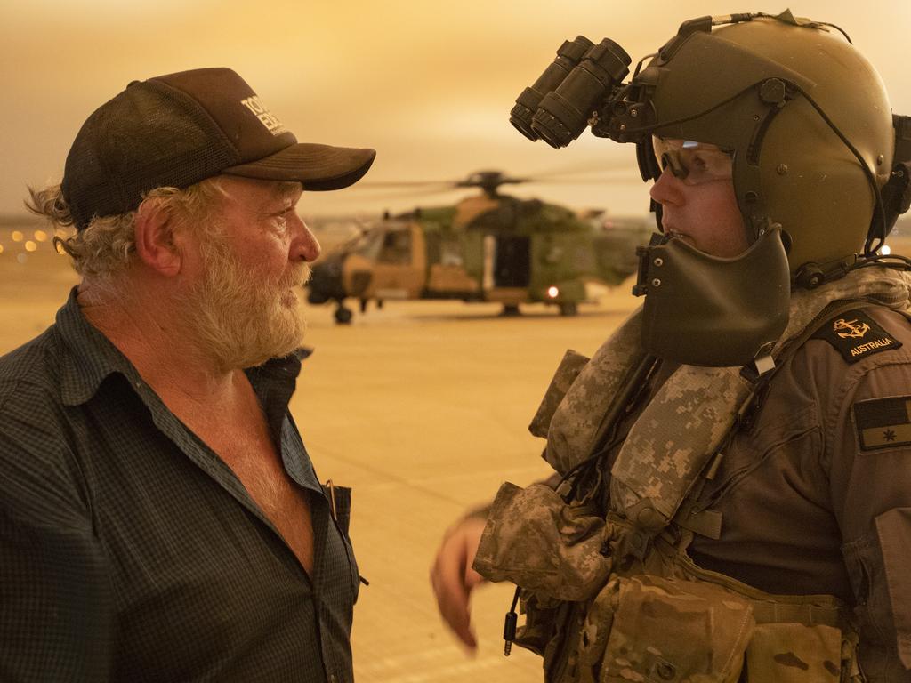 Mr Warren Usher thanks Royal Australian Navy Aircrewman Leading Seaman Brenton Menz of 808 Squadron, after the evacuation from his remote rural property located in the east of the Moreton National Park. Picture: ADF