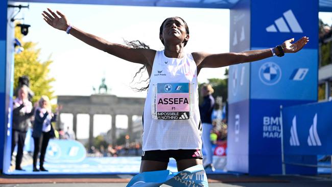 Ethiopia's Tigist Assefa celebrates after smashing the women's marathon world record by crossing the finish line to win the women's race of the Berlin Marathon on September 24, 2023 in Berlin, Germany. (Photo by Tobias SCHWARZ / AFP)