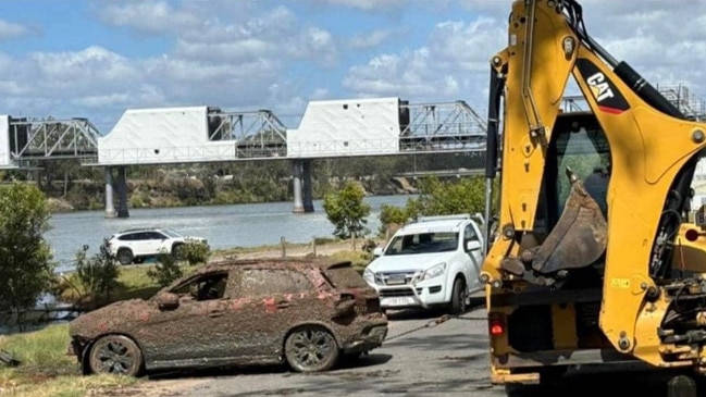 A small SUV is pulled out of the Burnett River under the inner city's main traffic bridge on October 16, 2024.