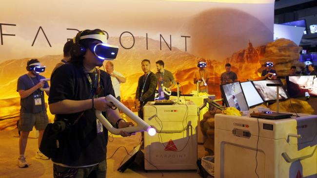 Visitors play FarPoint for PlayStation VR, a space adventure set on a hostile alien world, at the Electronic Entertainment Expo in Los Angeles. Picture: AP Photo/Nick Ut