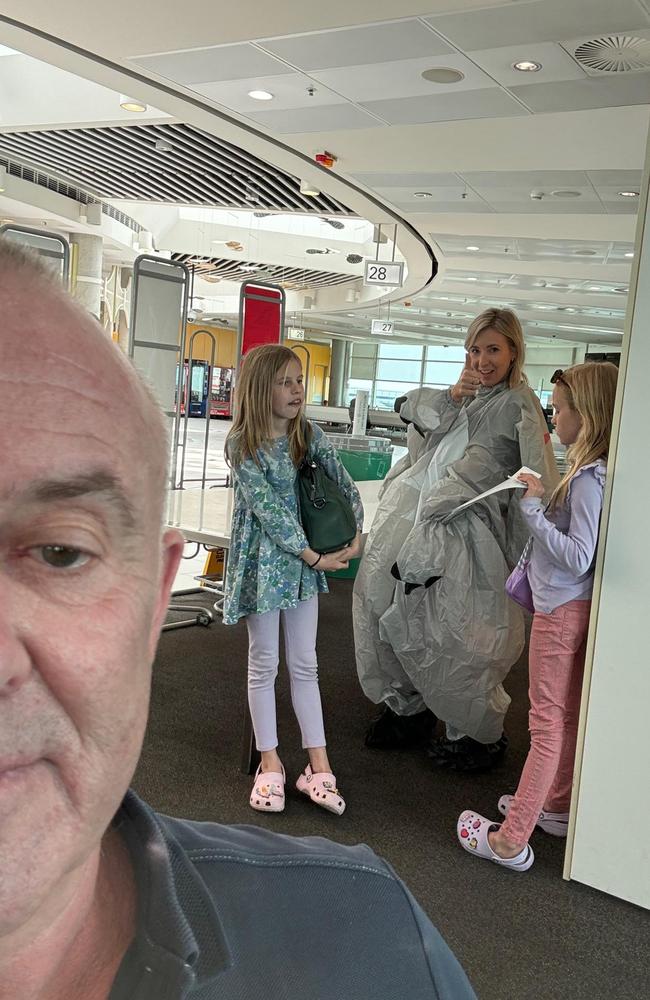 Greg Bartlett, 62, takes a selfie with his daughter Janelle Spies and two of her daughters as she gets ready at the Brisbane domestic airport to surprise her two unsuspecting sisters on September 26. Picture: Supplied