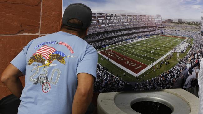 A football fan checks a rendering for a proposed NFL football stadium by the owners of the San Diego Chargers and Oakland Raiders.