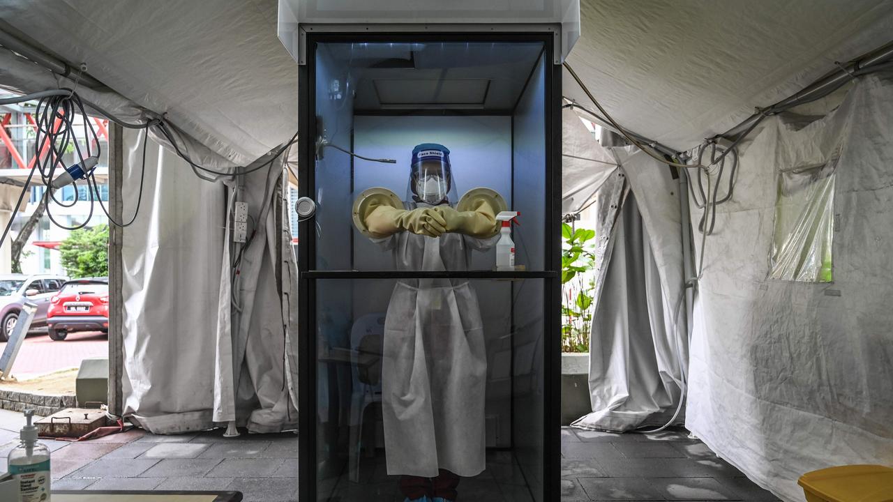 A health worker stands inside a non-contact chamber called the "CoV SHIELD" before taking swab test samples at Sunway Medical Center in Subang Jaya. Picture: Mohd Rasfan / AFP