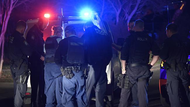 Police gather around a person arrested at the scene on Friday. Picture: Gordon McComiskie