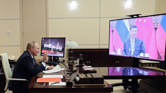 Vladimir Putin waves to China’s President Xi Jinping during a meeting via video in December. Picture: AFP