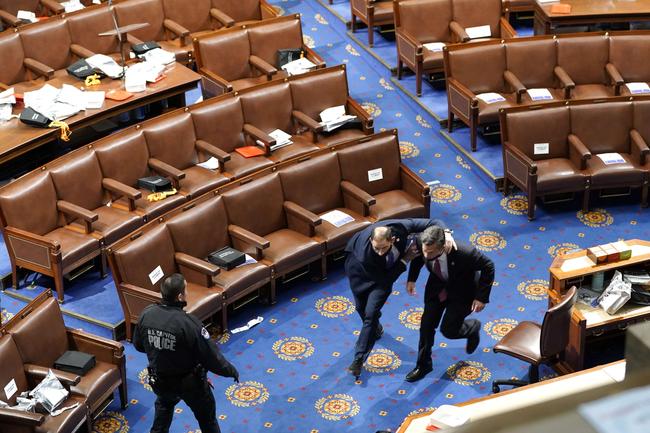 WASHINGTON, DC: Members of congress run for cover as protesters try to enter the House Chamber during a joint session of Congress Picture: Drew Angerer/Getty Images/AFP