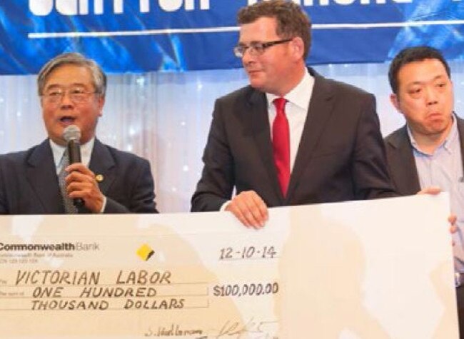 Hong Lim, Daniel Andrews and Guo Jing Chen as the Labor leader gets a cheque from Mr Lim's Clarinda branch.