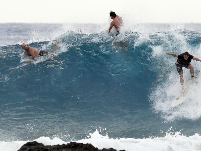 Surfers are seen at Snapper Rocks on the Gold Coast , Thursday February 21, 2019. Huge swells and high tides are set to pummelling south-east Queensland beaches over the coming days as Cyclone Oma tracks towards the Queensland coast. (AAP Image/Dave Hunt)