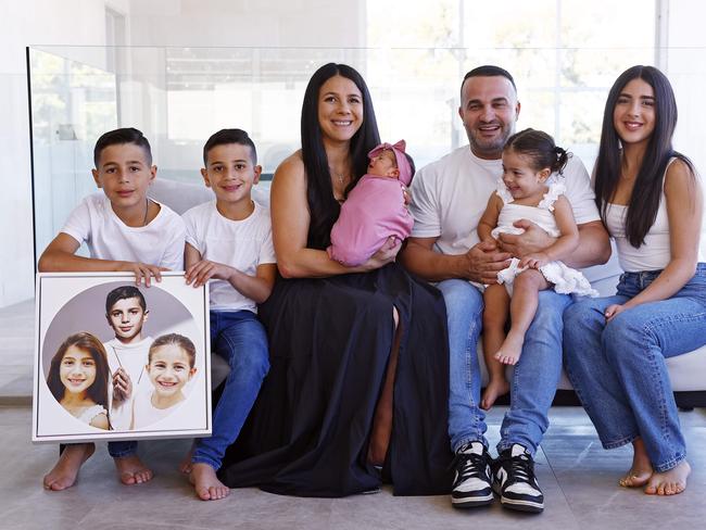 Danny and Leila Abdallah with their newborn baby and other children (from left) Alex, Michael, Selina and Liana as well as a photo of their three children killed by a drunk driver. Picture: Sam Ruttyn