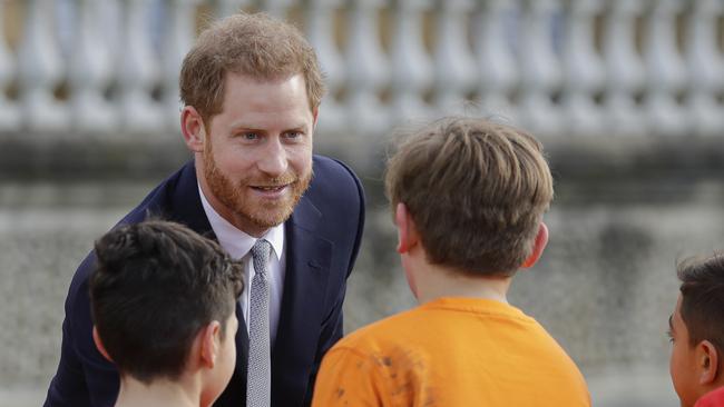Britain's Prince Harry greets schoolchildren in the gardens at Buckingham Palace in London. Picture: AP