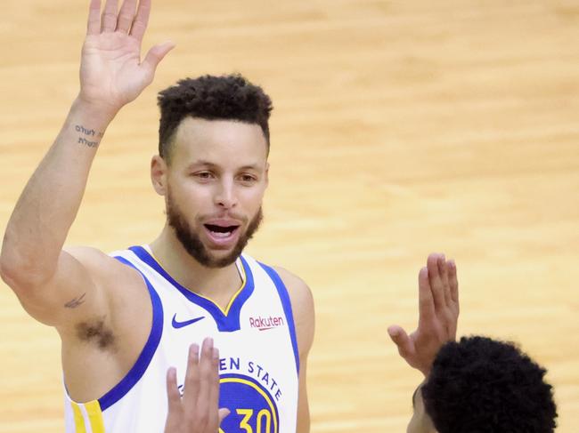 HOUSTON, TEXAS - MARCH 17: Stephen Curry #30 of the Golden State Warriors high fives Jordan Poole #3 during the second quarter of a game against the Houston Rockets at the Toyota Center on March 17, 2021 in Houston, Texas. NOTE TO USER: User expressly acknowledges and agrees that, by downloading and or using this photograph, User is consenting to the terms and conditions of the Getty Images License Agreement. (Photo by Carmen Mandato/Getty Images)